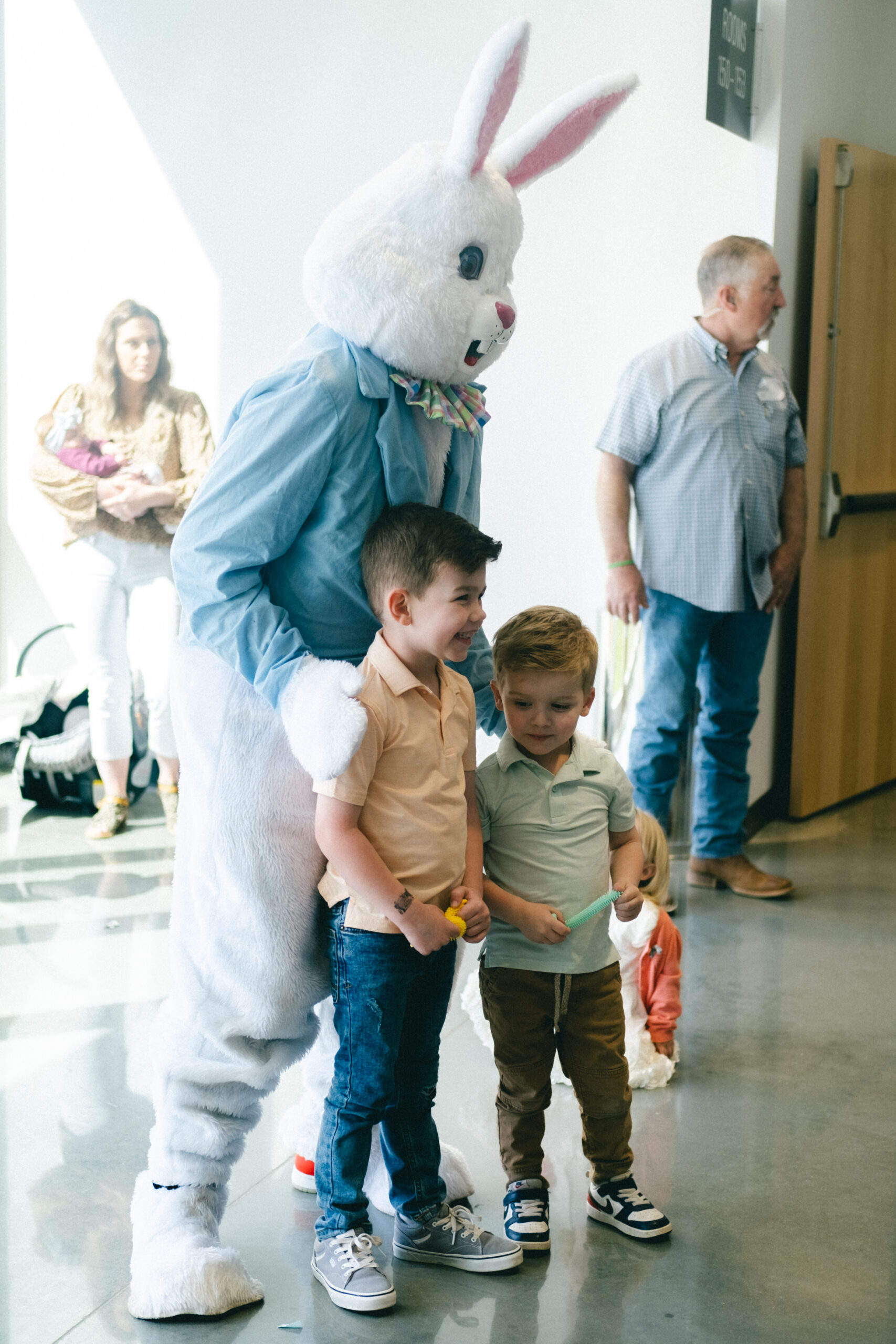 Easter Bunny posing for pictures with two children.
